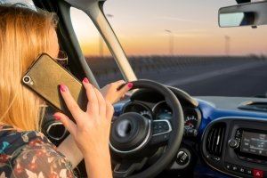 Woman driving while talking on the phone